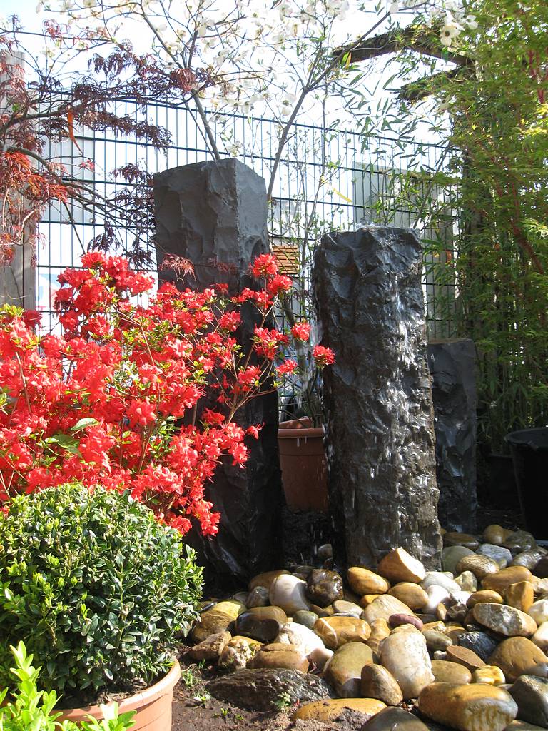 Behauene Basaltquellsteine mit Ahorn, Bux und Rhododendron