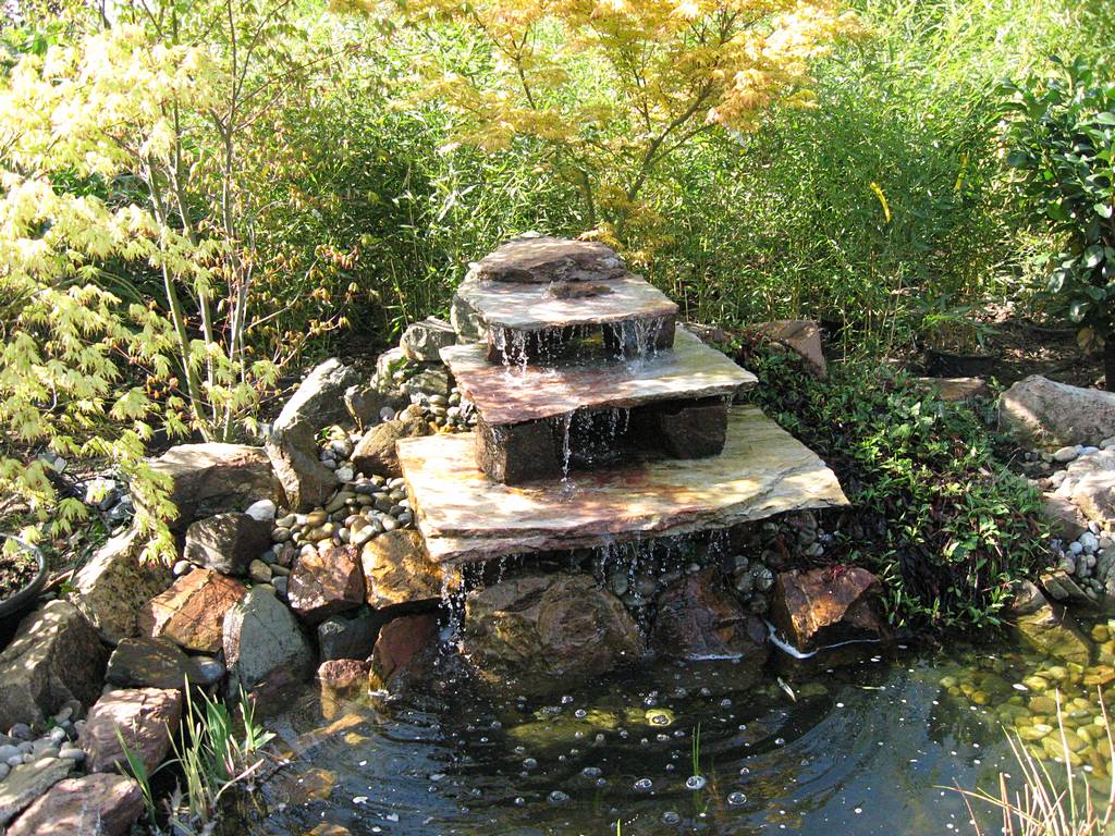 Treppenbrunnen verteilen das Wasser in kleinen Mengen in den Teich.