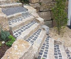 Rustikal gemauerte Gartentreppe aus Basaltpflaster und behauenen Natursteinen