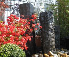 Behauene Basaltquellsteine mit Ahorn, Bux und Rhododendron
