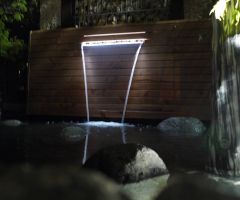 In der Dämmerung wird der Wasserfallbrunnen beleuchtet.