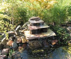 Treppenbrunnen verteilen das Wasser in kleinen Mengen in den Teich.